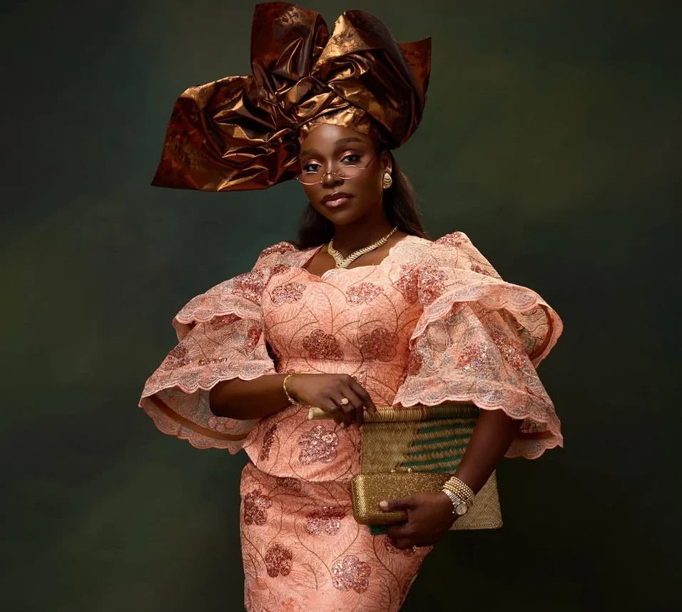 Nigerian actress and influencer Tomike Adeoye in a modernised buba with a full-chested blouse and dramatic sleeves paired with a mini skirt, finished with an oversized gele.