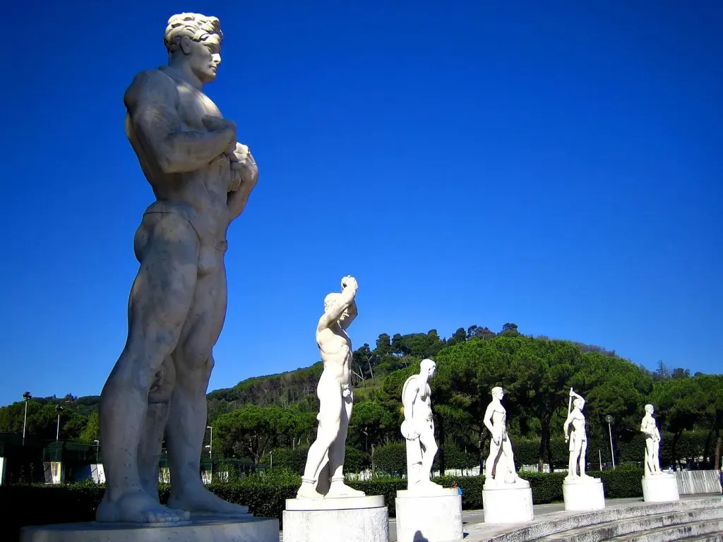The picture shows the row of athlete statues listing the Foro dei Marmi in Rome. The athletes are depicted as ancient classic athletes.