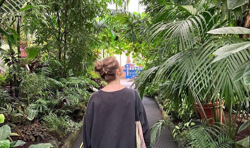 Image shows author walking through greenery.