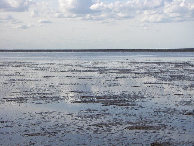 Image depicting a tide coming in along the edge of a beach. Image taken by Ben Harris, sourced from geograph.org.uk, Wikimedia Commons,