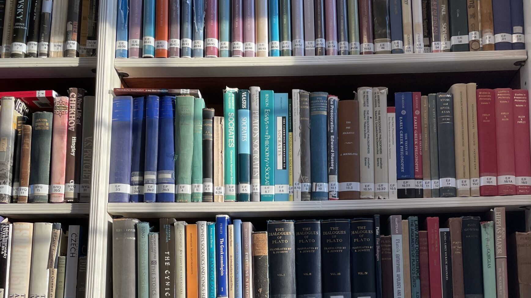 image of a white bookcase filled with colourful books