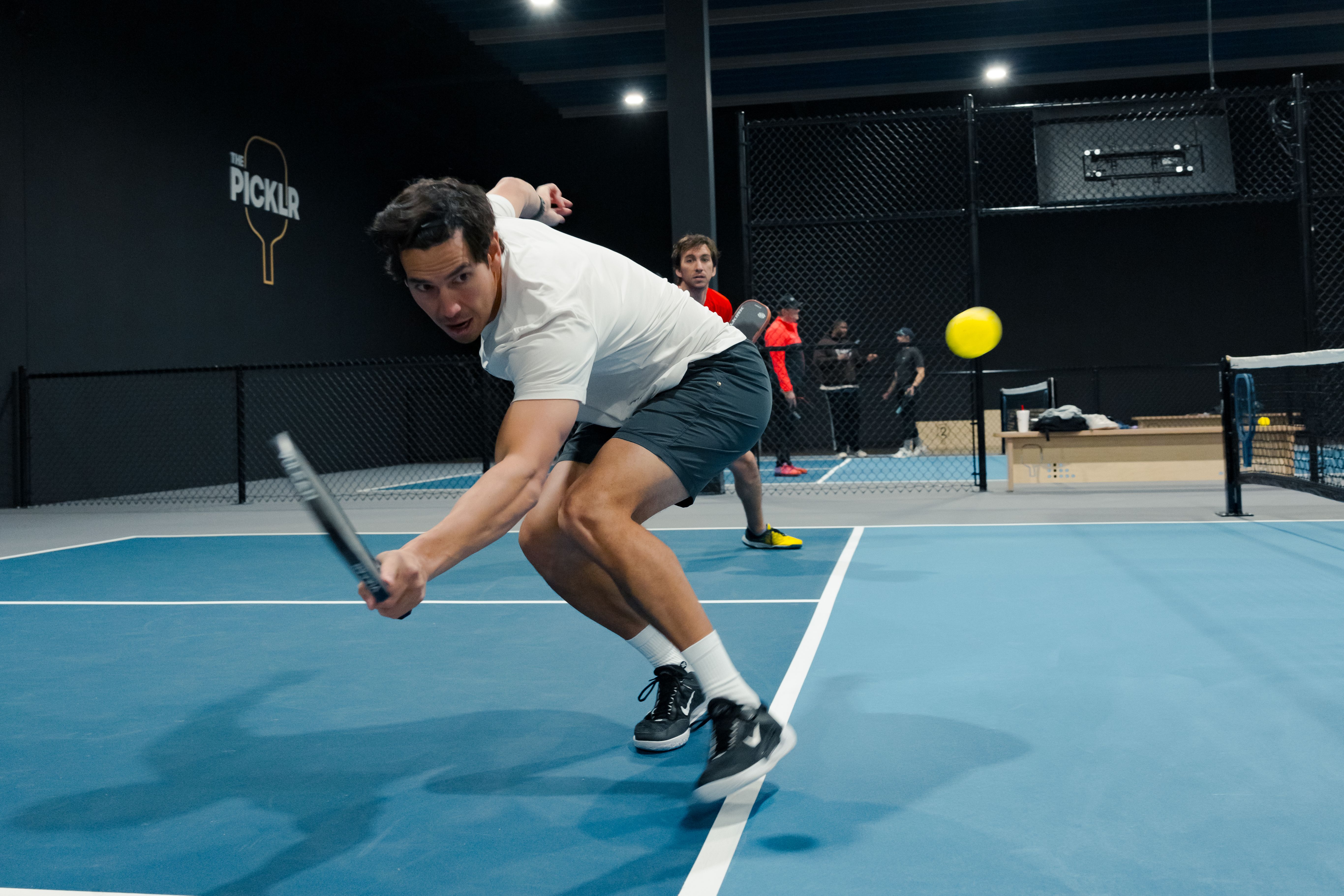 Pickleball player returning the pickleball with his backhand