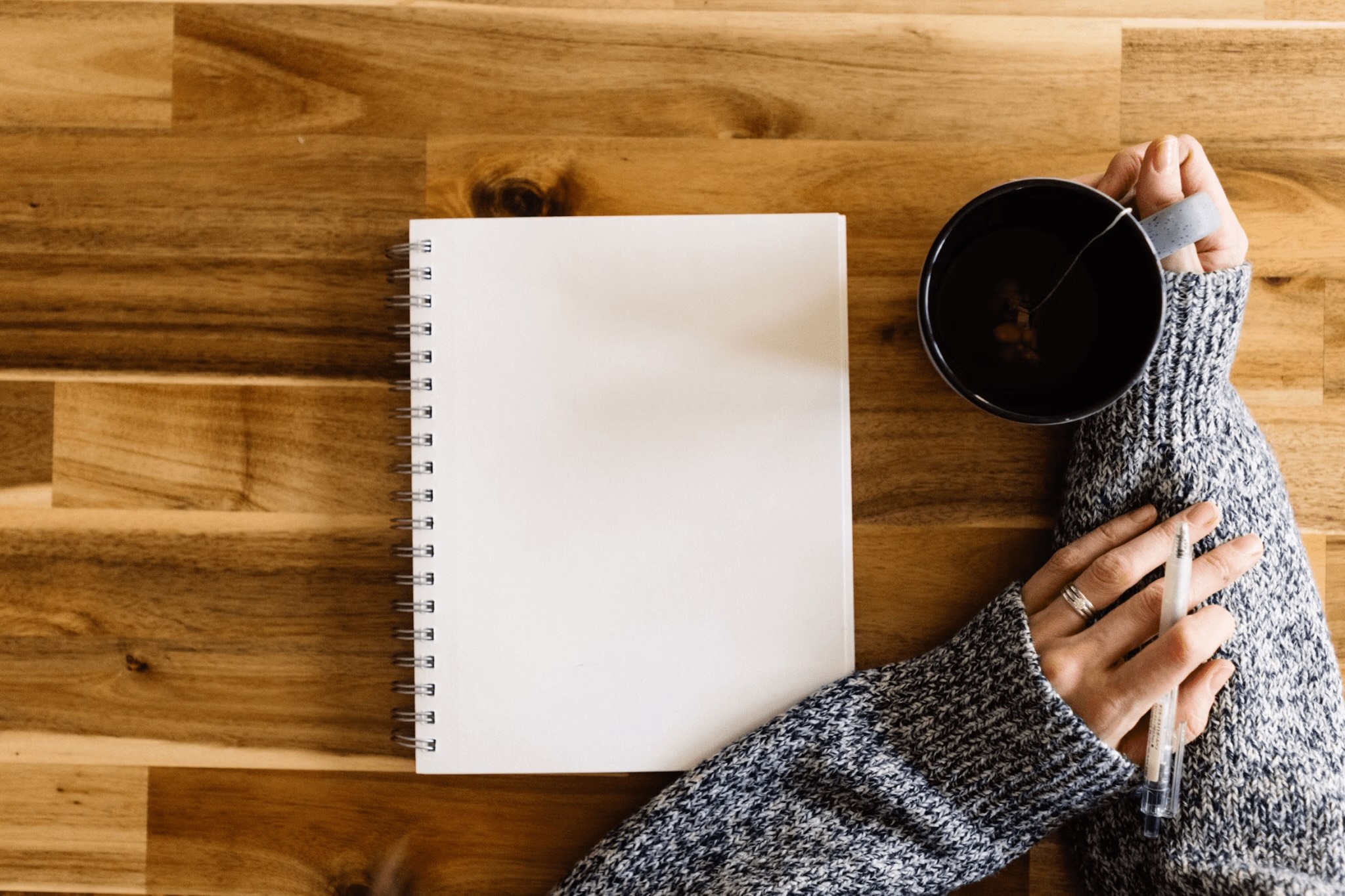 Person writing with a cup of coffee