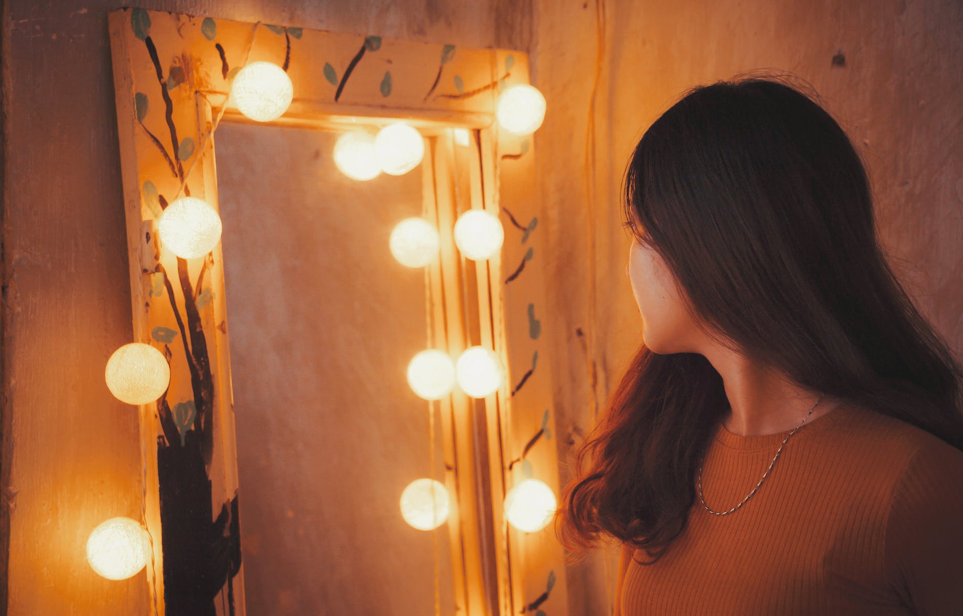 woman facing vanity mirror