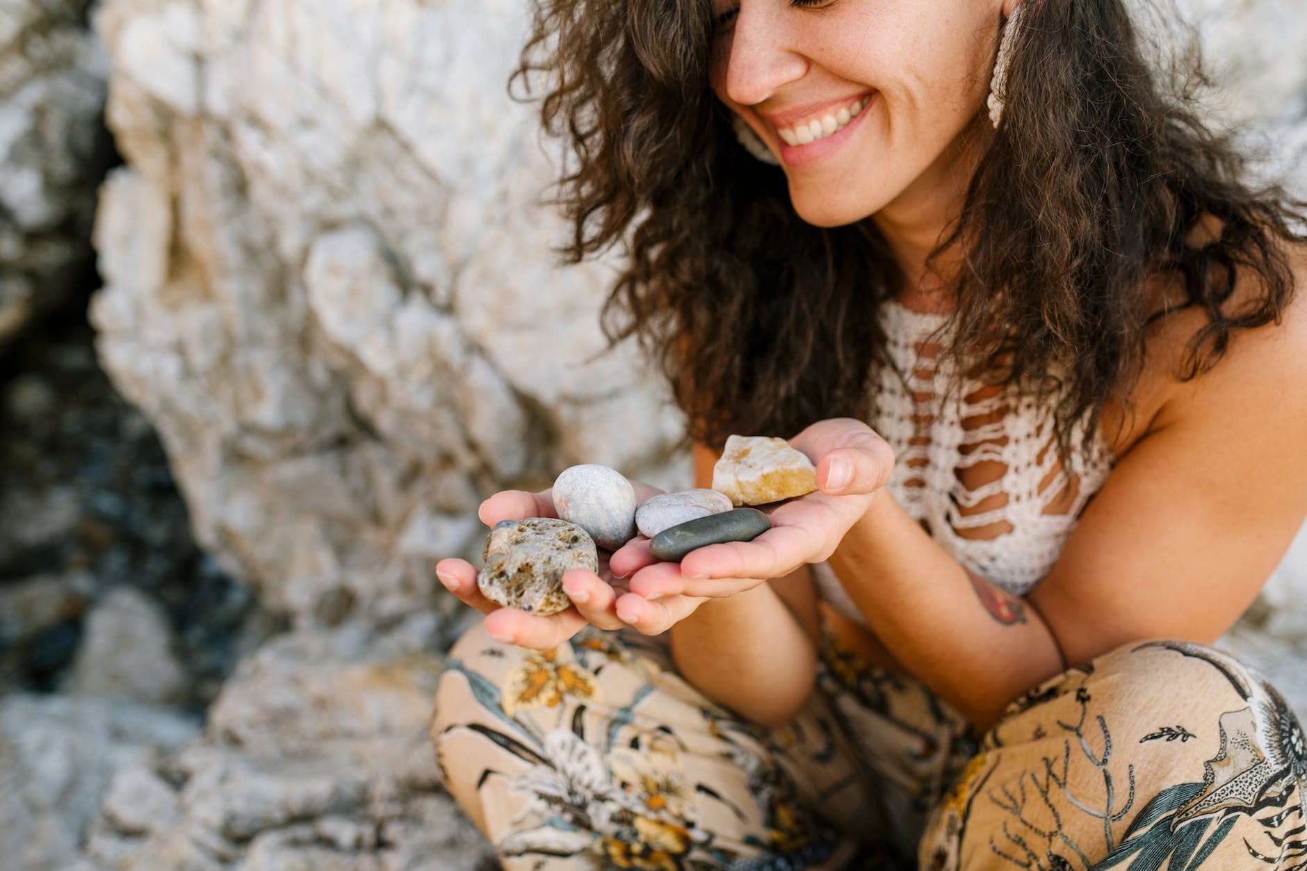 woman admiring small pebbles in mountain terrain