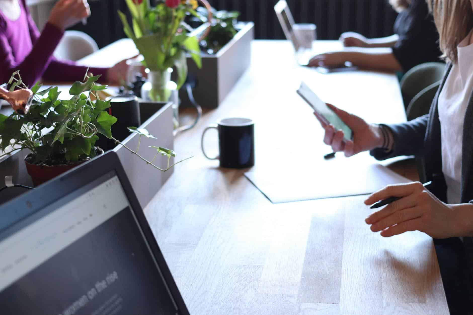 person holding smartphone in front of table