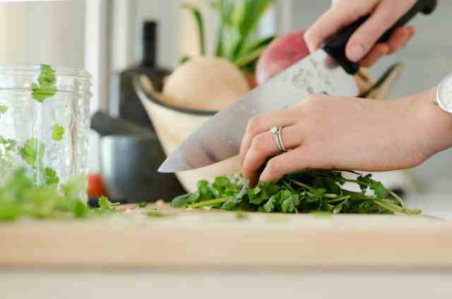 a woman cutting up parsley 