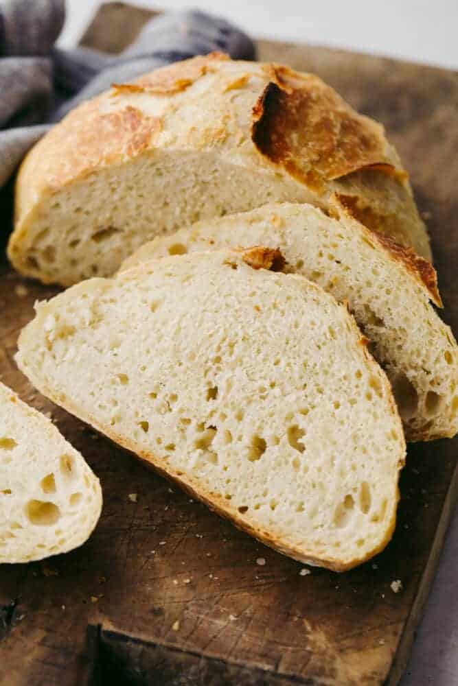 This amazing artisan no-knead bread recipe will make you feel like a rock-star baker! It has a perfectly crispy crust with a soft and chewy texture on the inside. Plus, it couldn't be easier to make from home! No knead bread cut into slices.