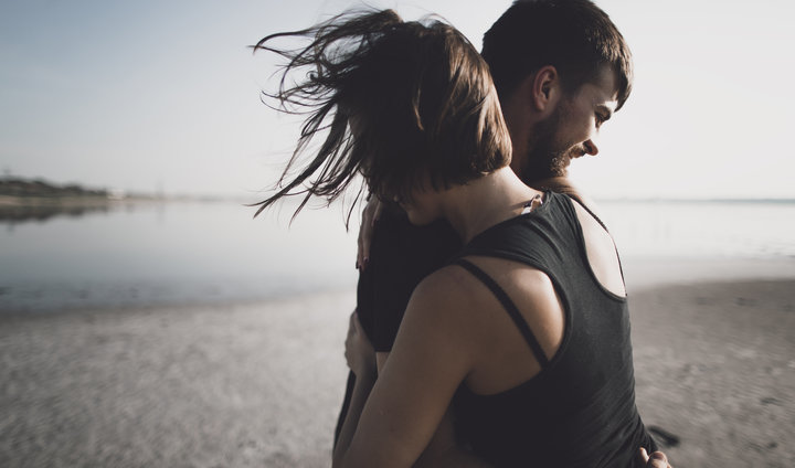 Caucasian couple hugging on beach