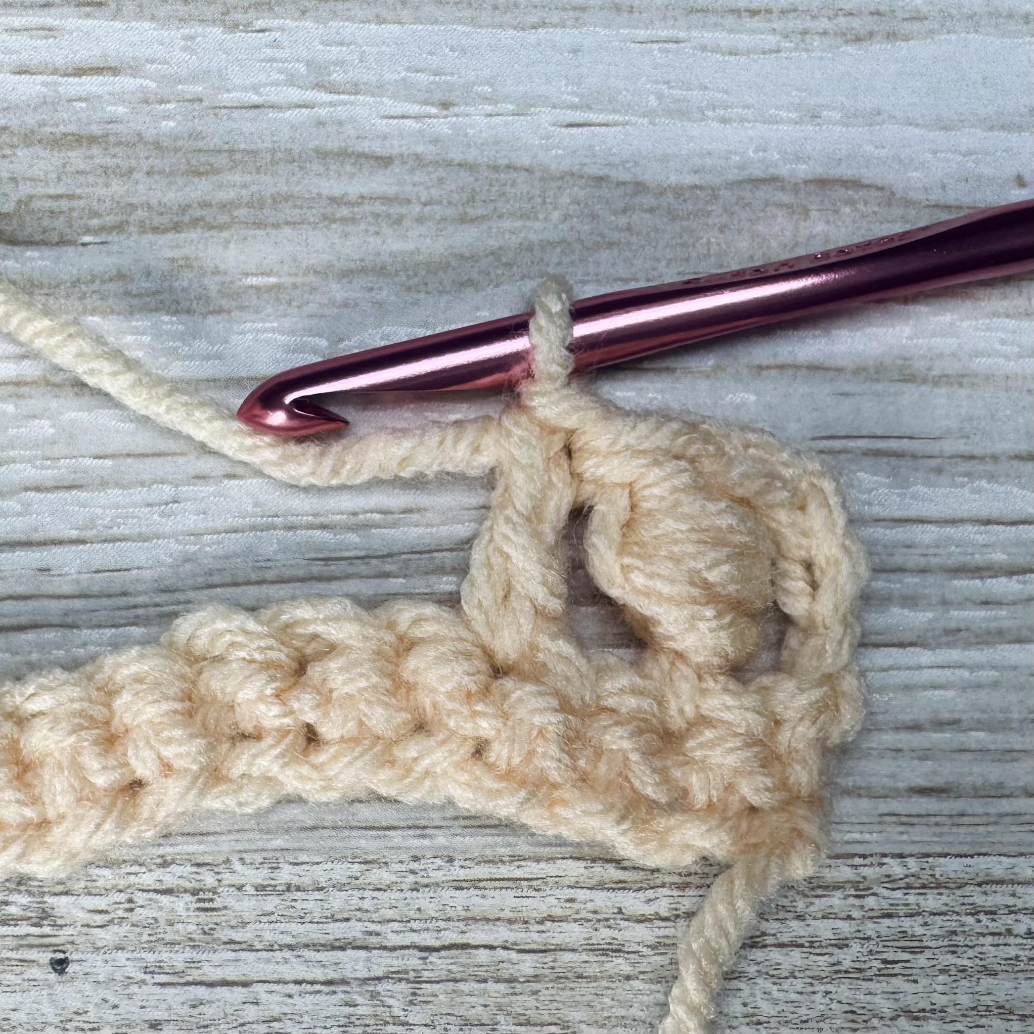 Skip one stitch and make a double crochet in the next stitch to begin the second bead stitch.