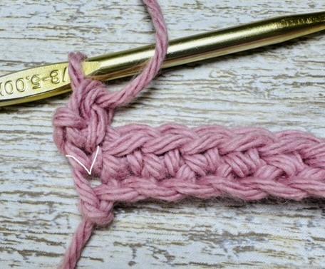 In the knit stitch you place a sc in the center of the "V" of the stitch you are working in.