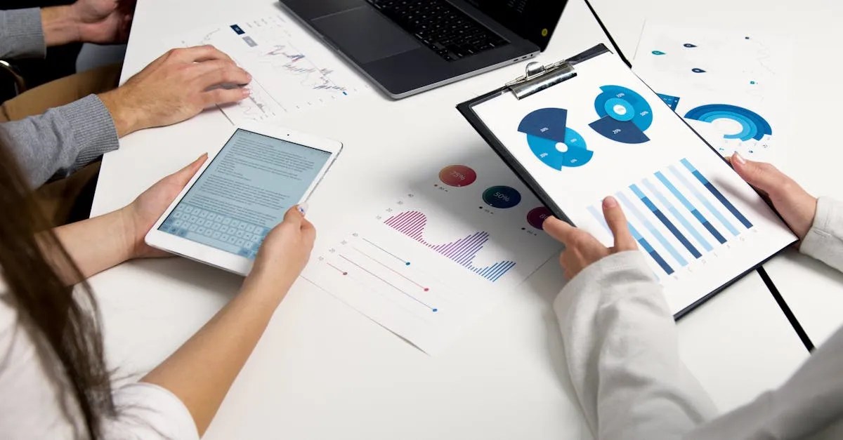 Colleagues reviewing printed charts and a tablet at a table