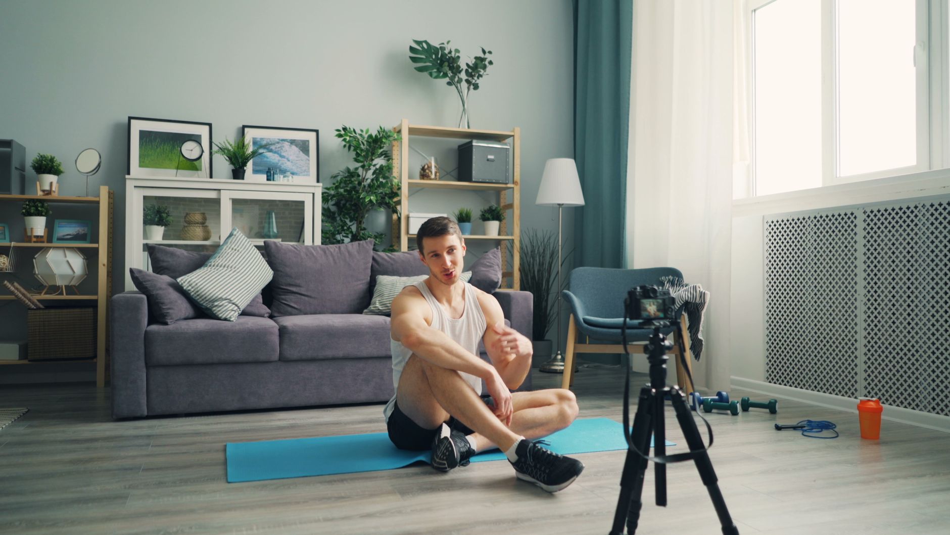 man exercising on mat with camera on tripod