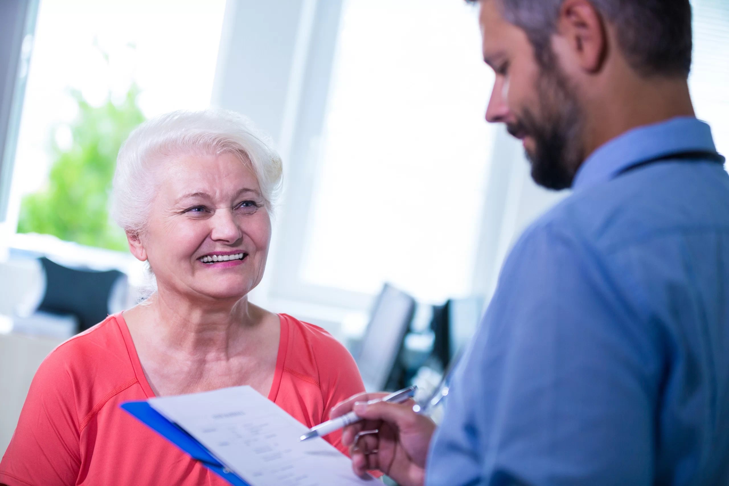 senior woman going over checklist with doctor