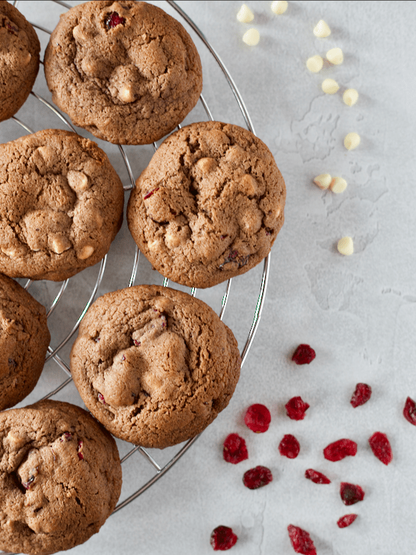 White chocolate and cranberry cookies sitting on a cooling tray