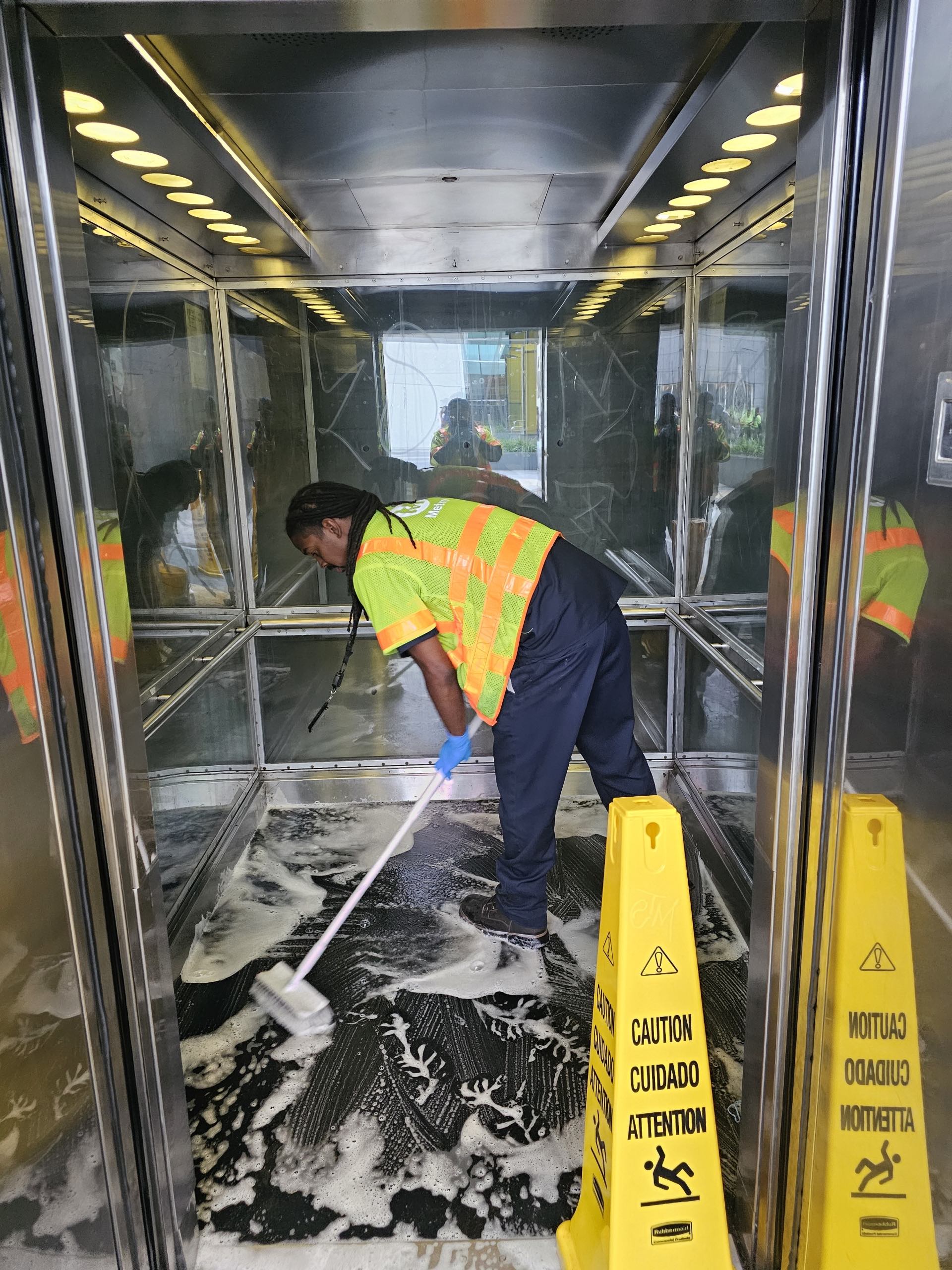 Metro employee mopping clean a Metro station elevator.