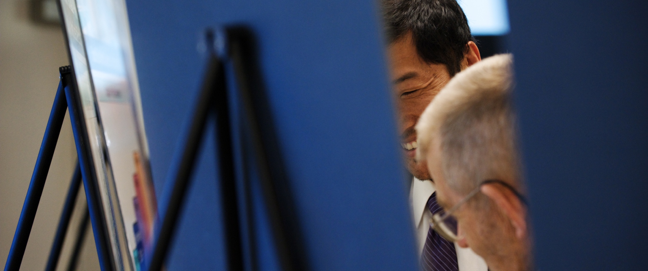 Two people looking at display boards during a Service Council Meeting.