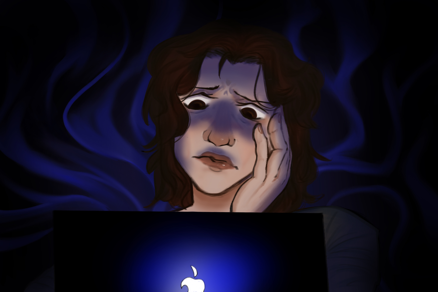 A woman in the dark looks at a Mac laptop.