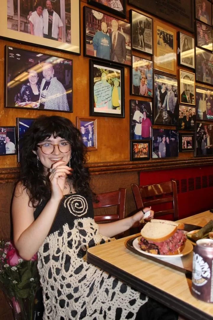 Sofia Vega sits in a restaurant with a sandwich in front of her