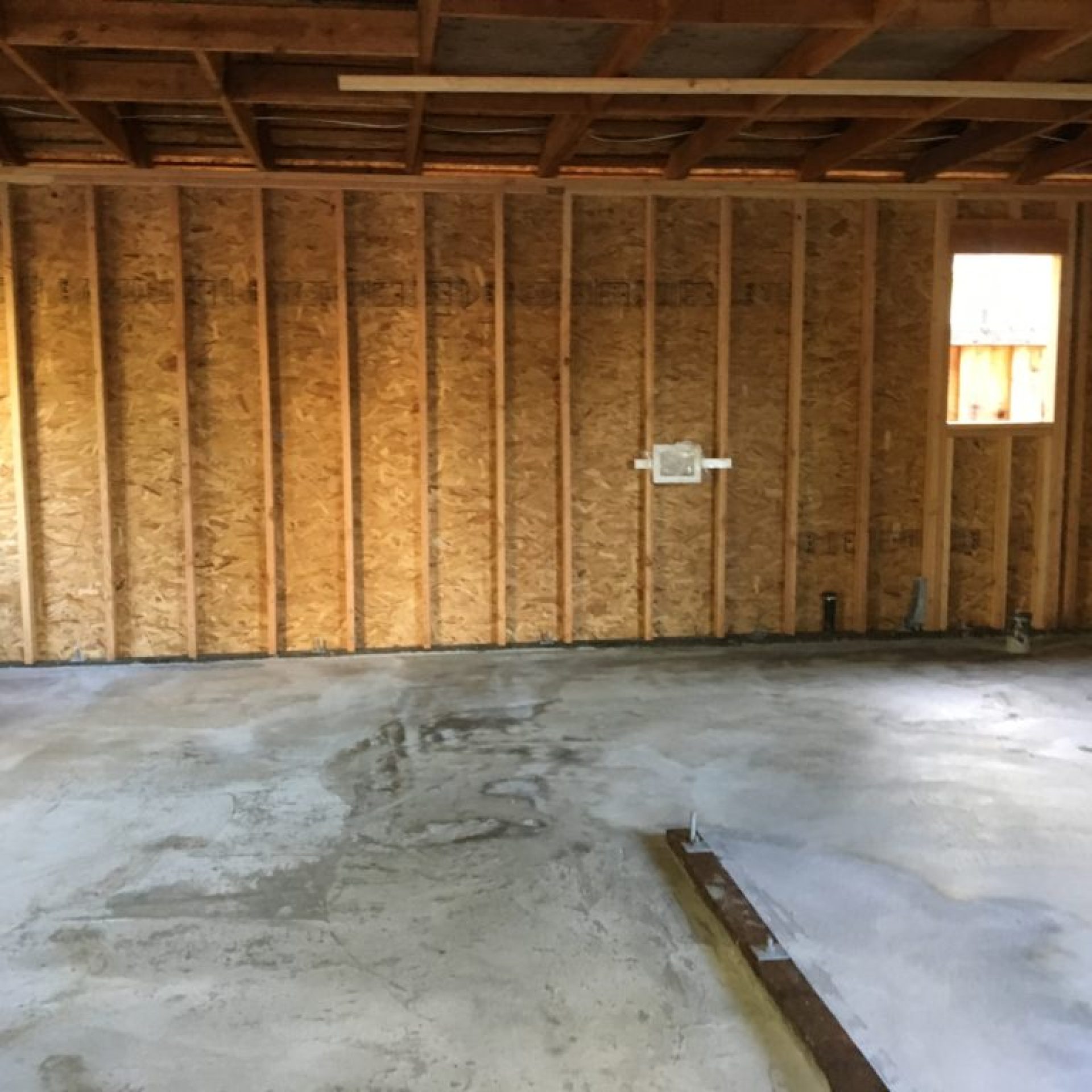 Interior of west wall framing during reconstruction over concrete slab