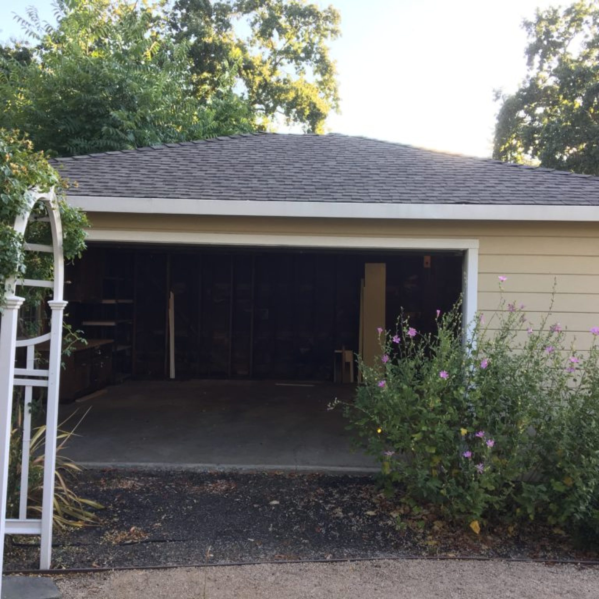 East garage wall before renovation with open dark garage interior