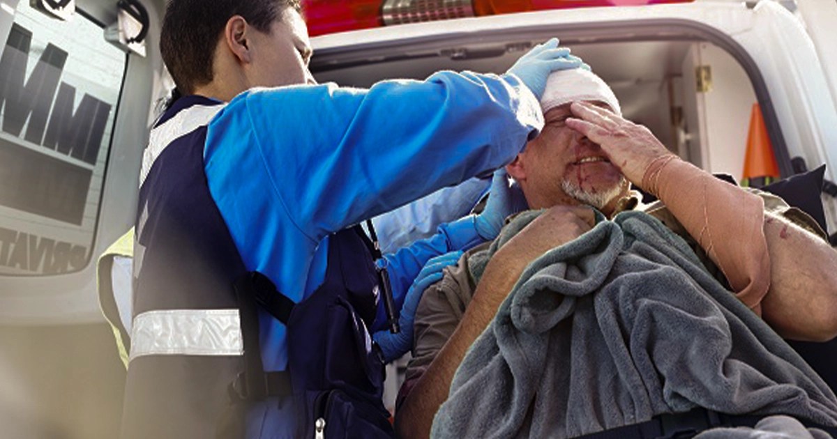 Emergency medic bandaging patient with suspected skull fracture