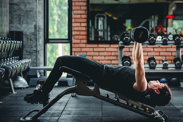 a man performing a decline dumbell press on an adjustable weights bench