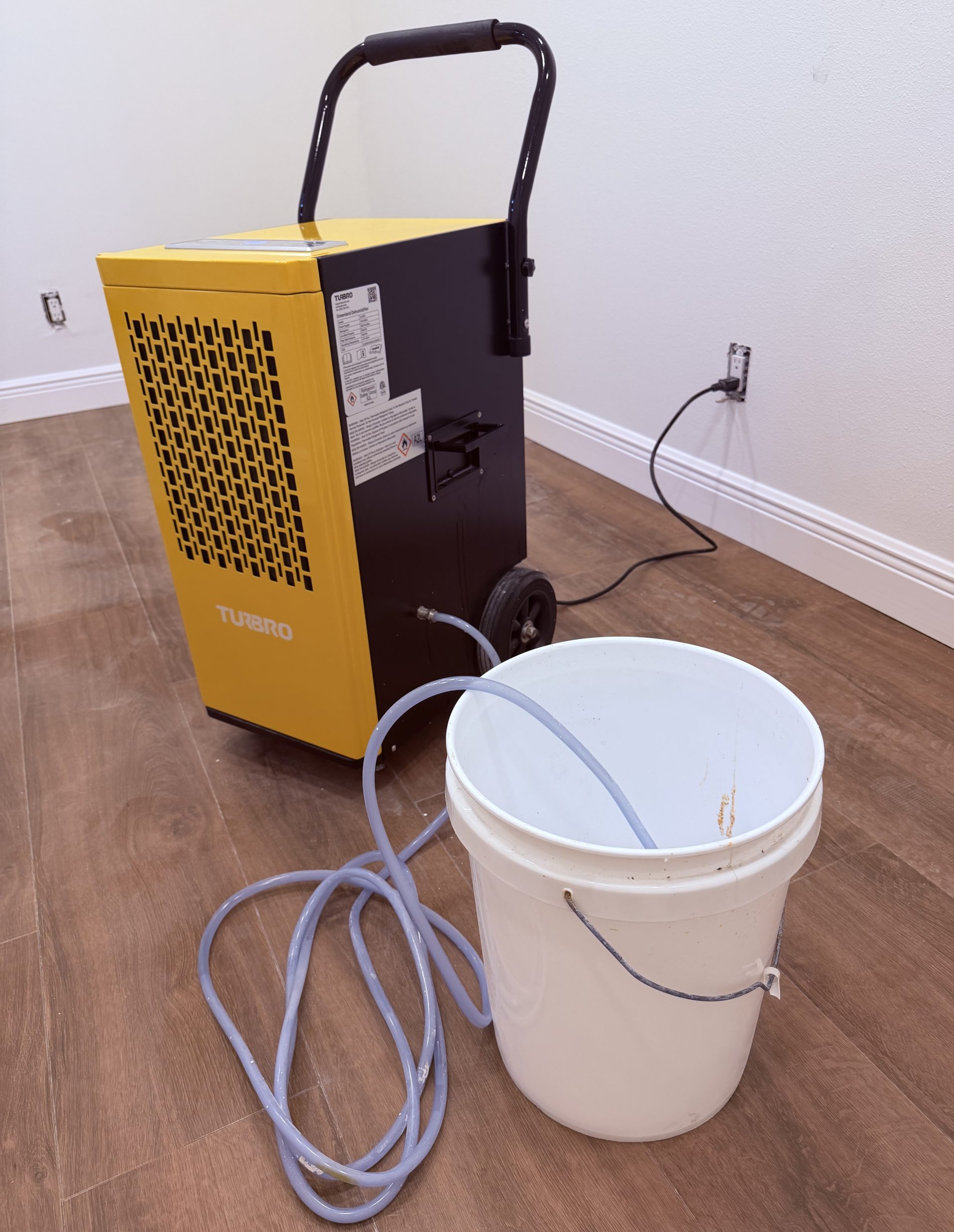 Turbro GL150P dehumidifier draining into a bucket with the pump hose