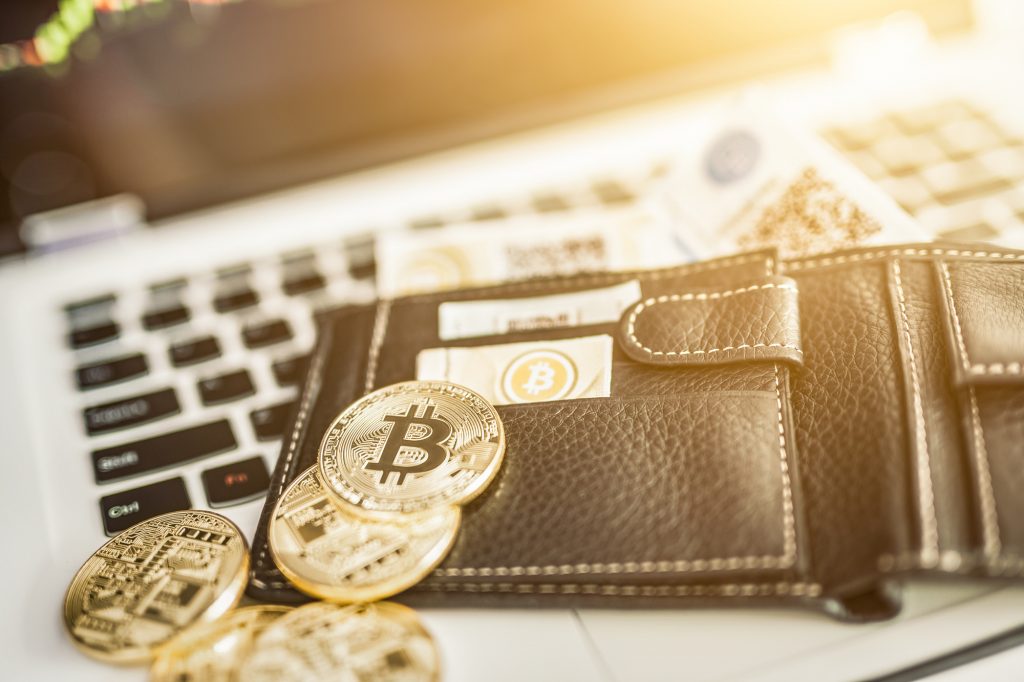 Bitcoin gold coin on top of a wallet