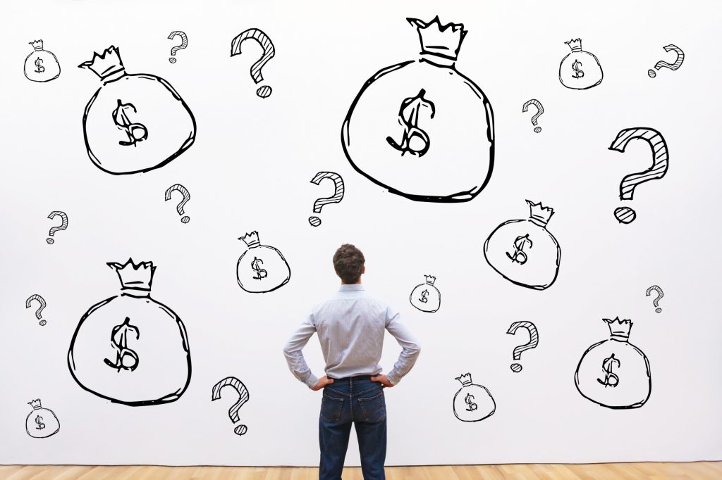 man looking into wall with drawings of bags of money