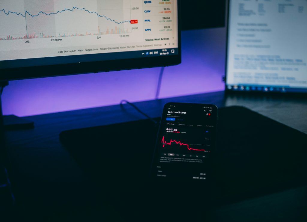 smartphone and computer screen with a trading chart