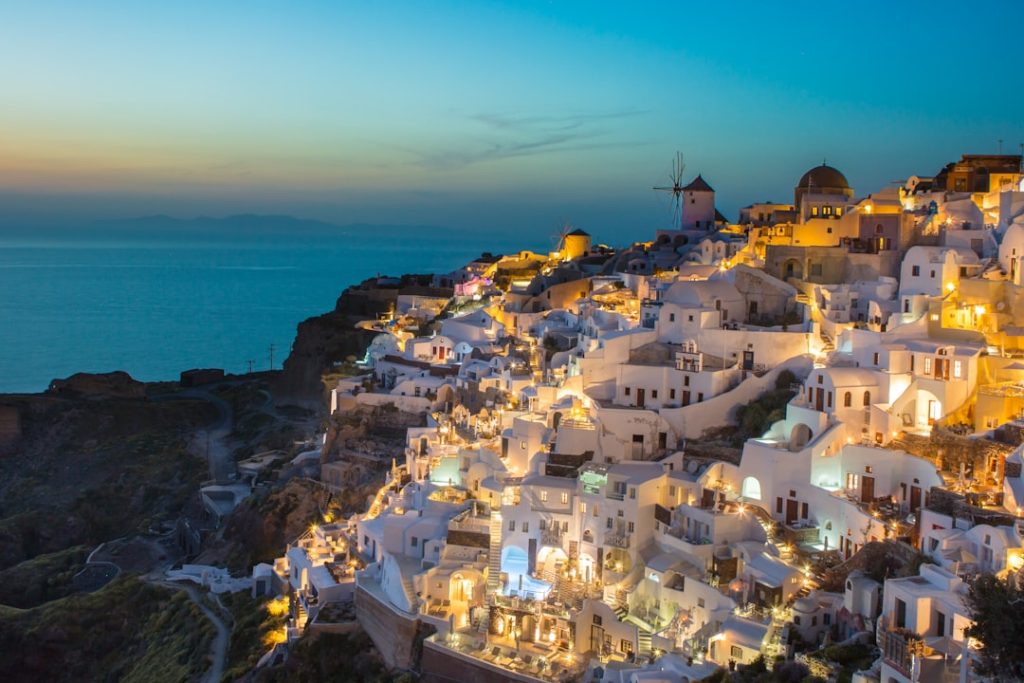 white and brown concrete houses on mountain near sea during daytime in Greece
