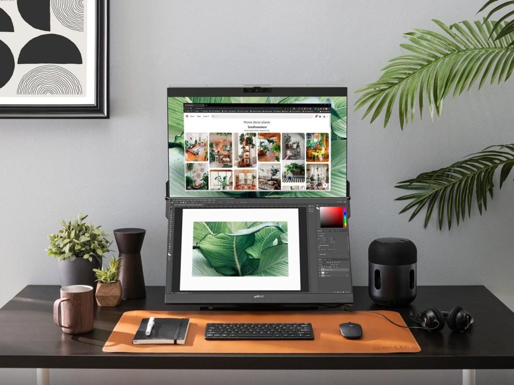 Vertically stacked dual-screen monitor on a modern home office desk showing photo editing software and botanical images.