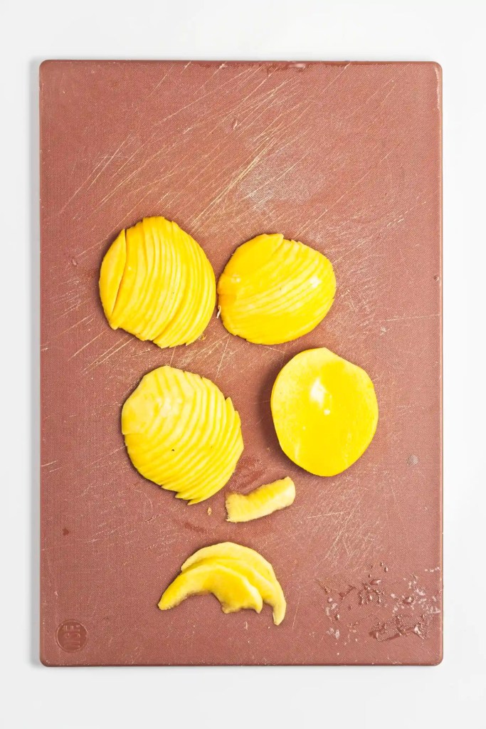 mango cut on w cutting board