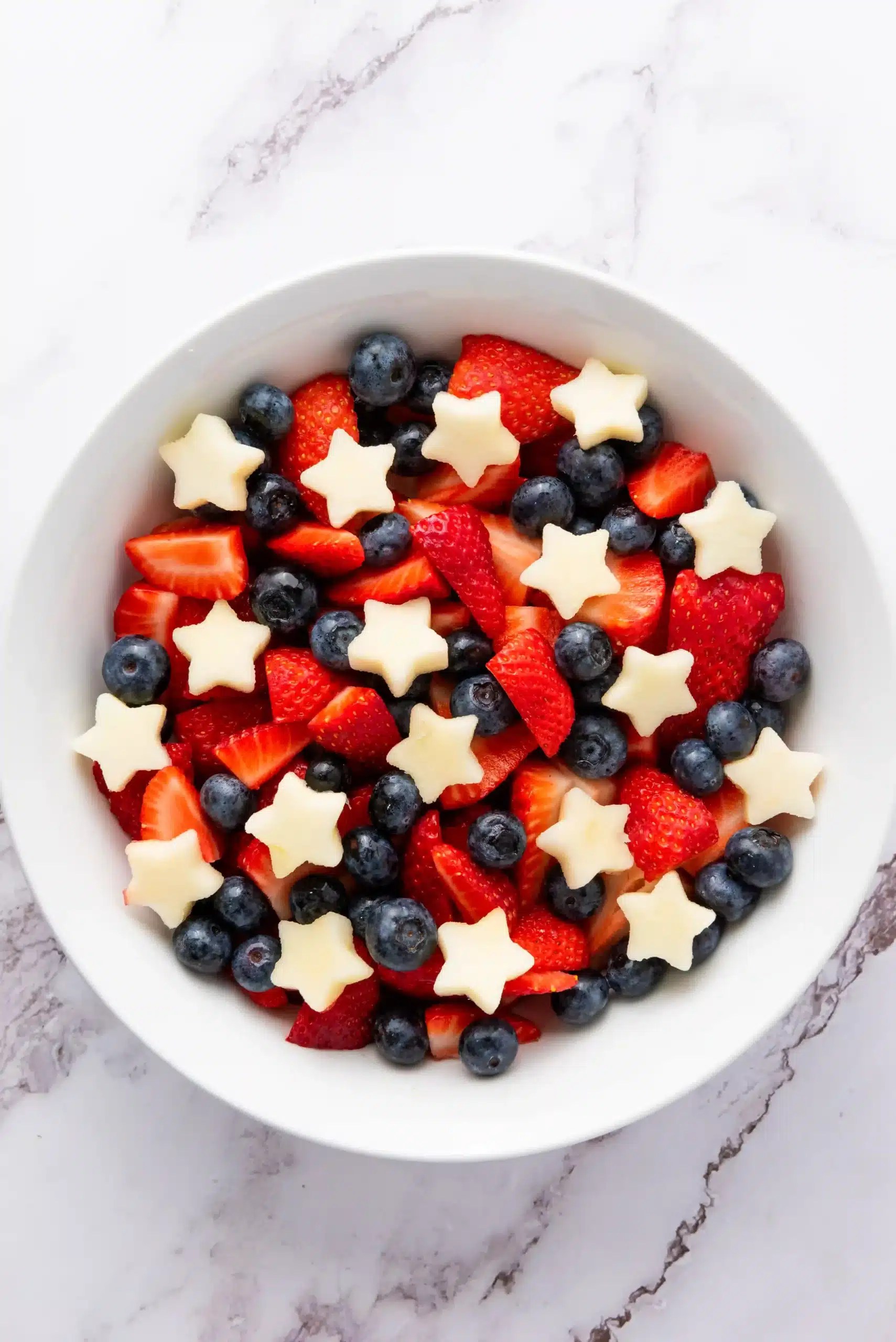 a fourth of july fruit salad with apples, strawberries, and blueberries