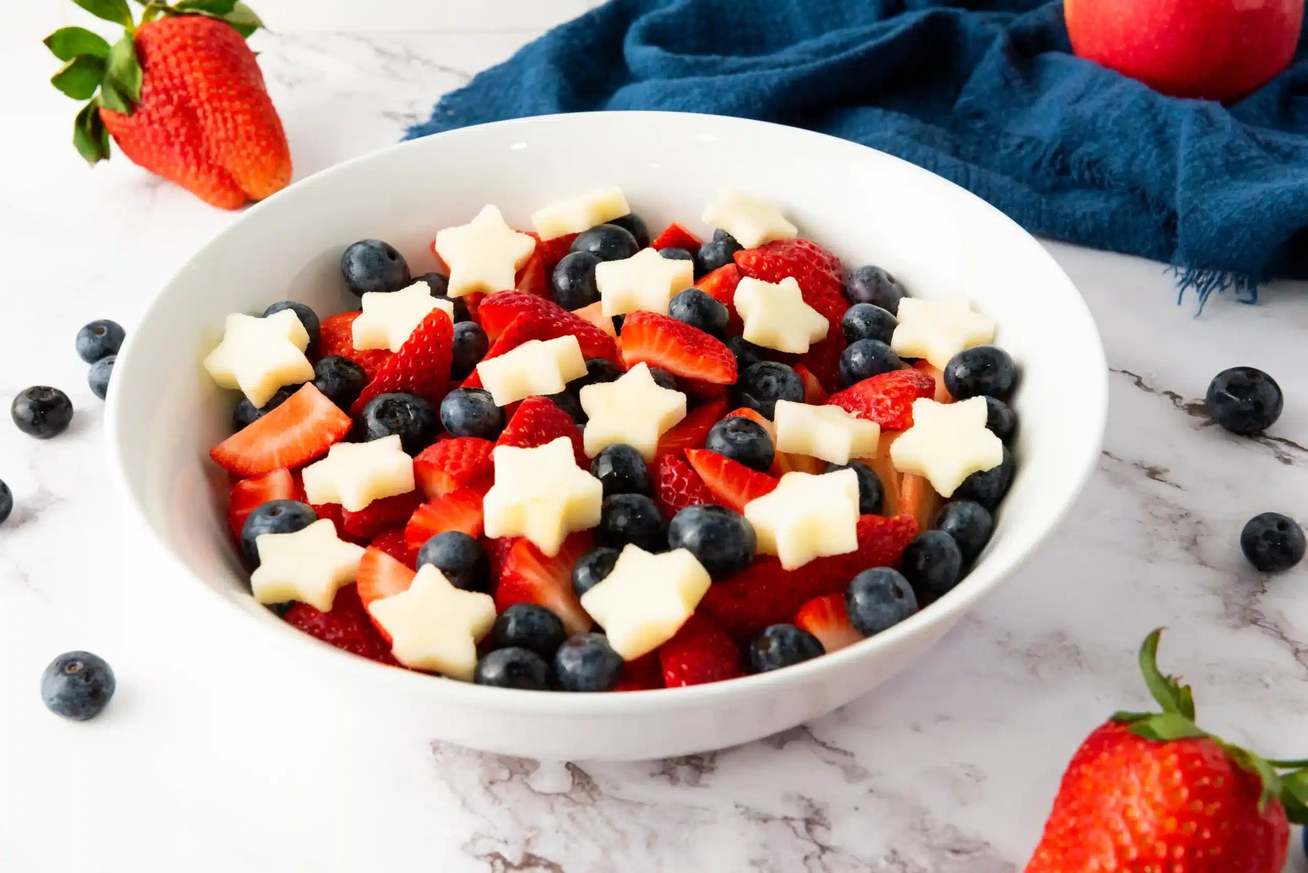a fourth of july fruit salad with apples, strawberries, and blueberries