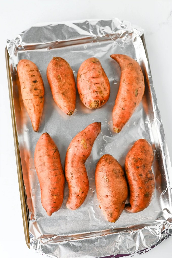 sweet potatoes on a baking pan with aluminum foil