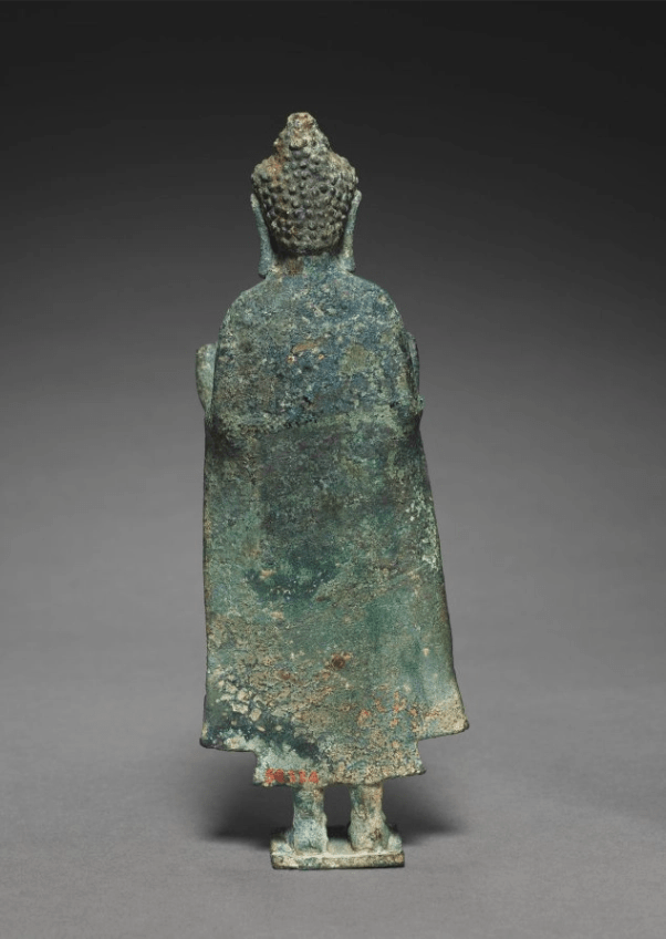 Teaching Buddha sculpture, back view showing robe folds and silhouette
