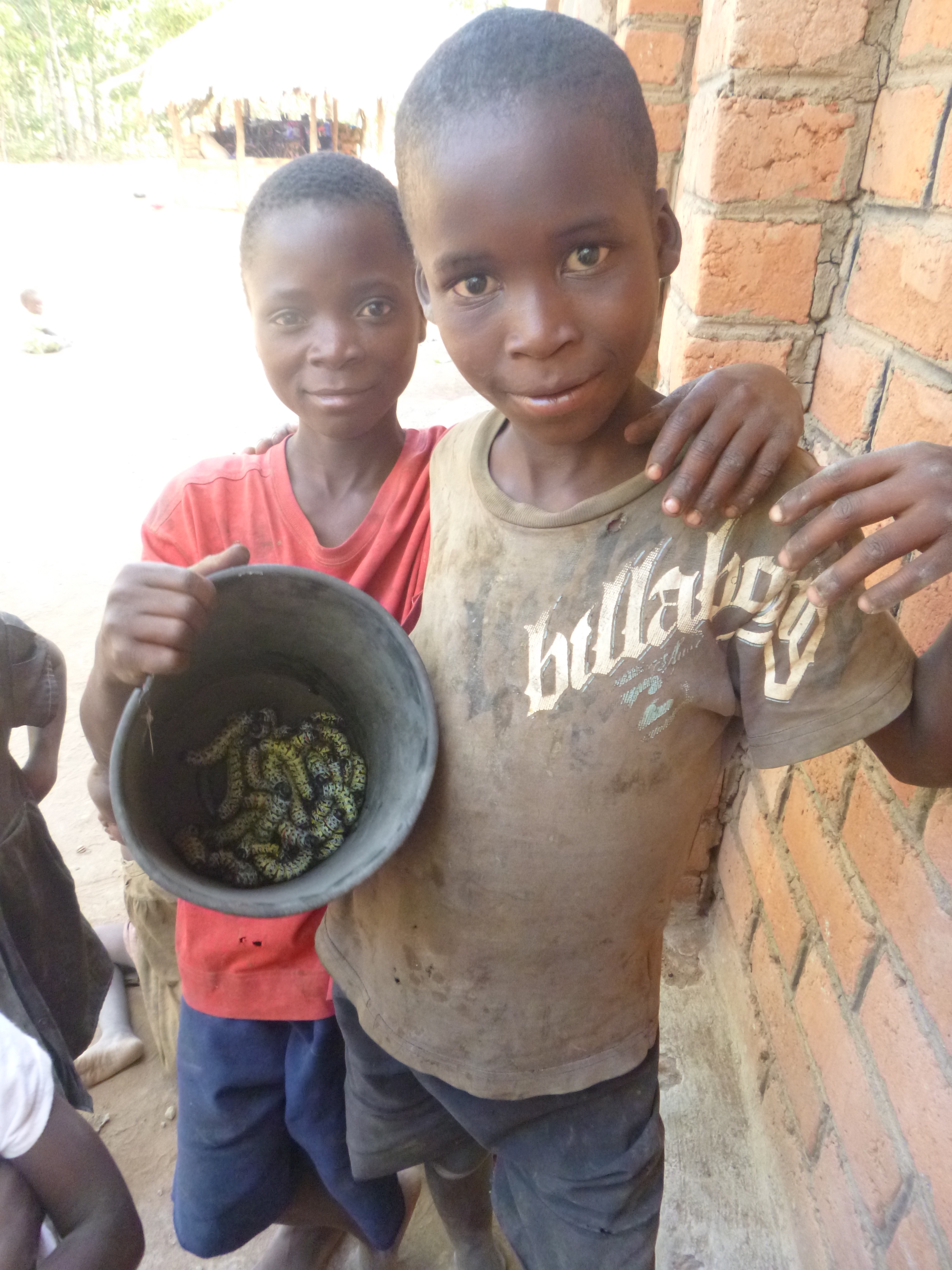 Bwalya poses with a new friend, who came to Mfuba with his family to harvest caterpillars.