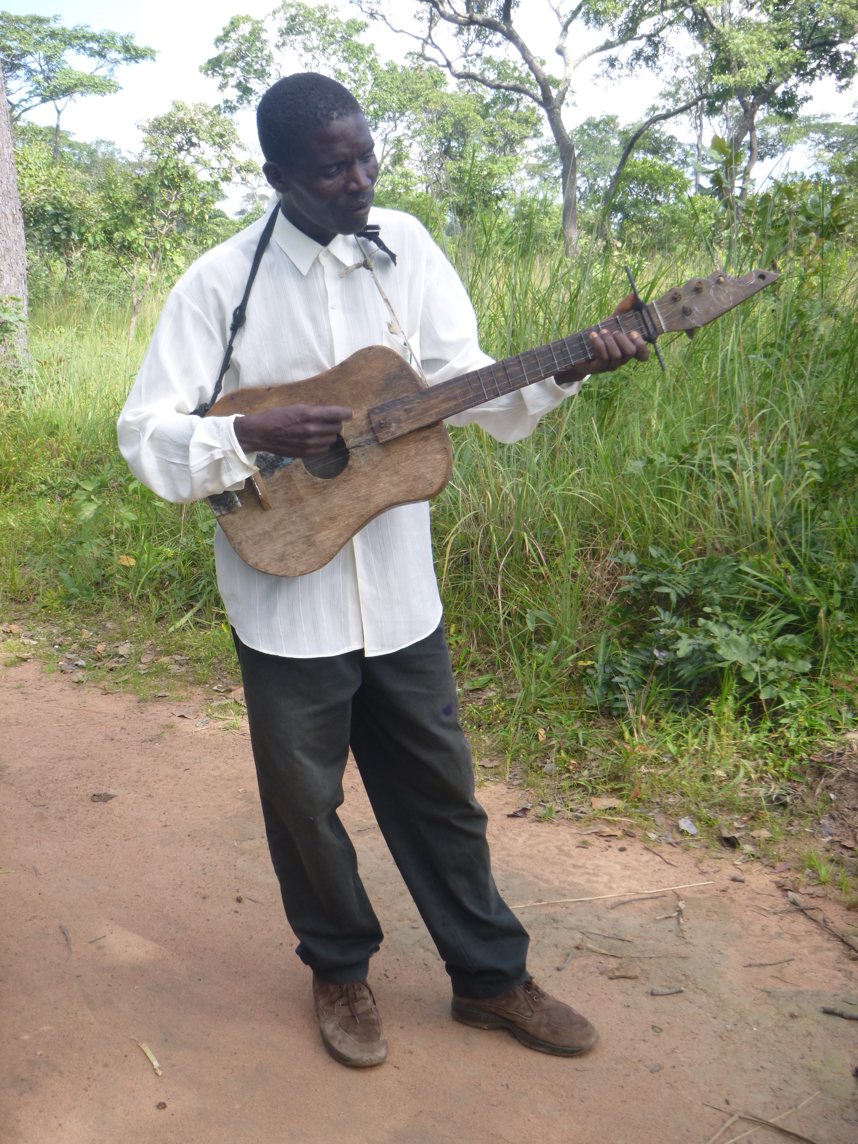 Ba Allan, trying unsuccessfully to play the bush guitar. ("Bush" because it's homemade.)