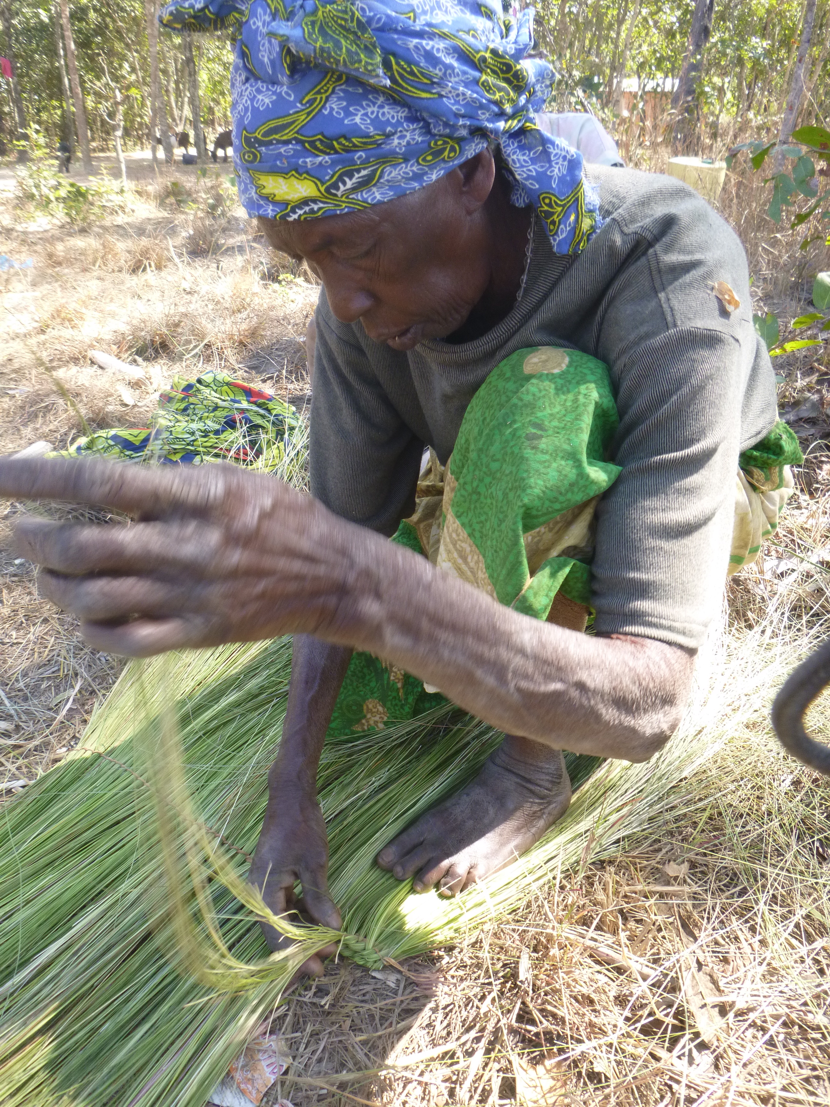 Banakulu Teba weaving wetland grasses into a broom.