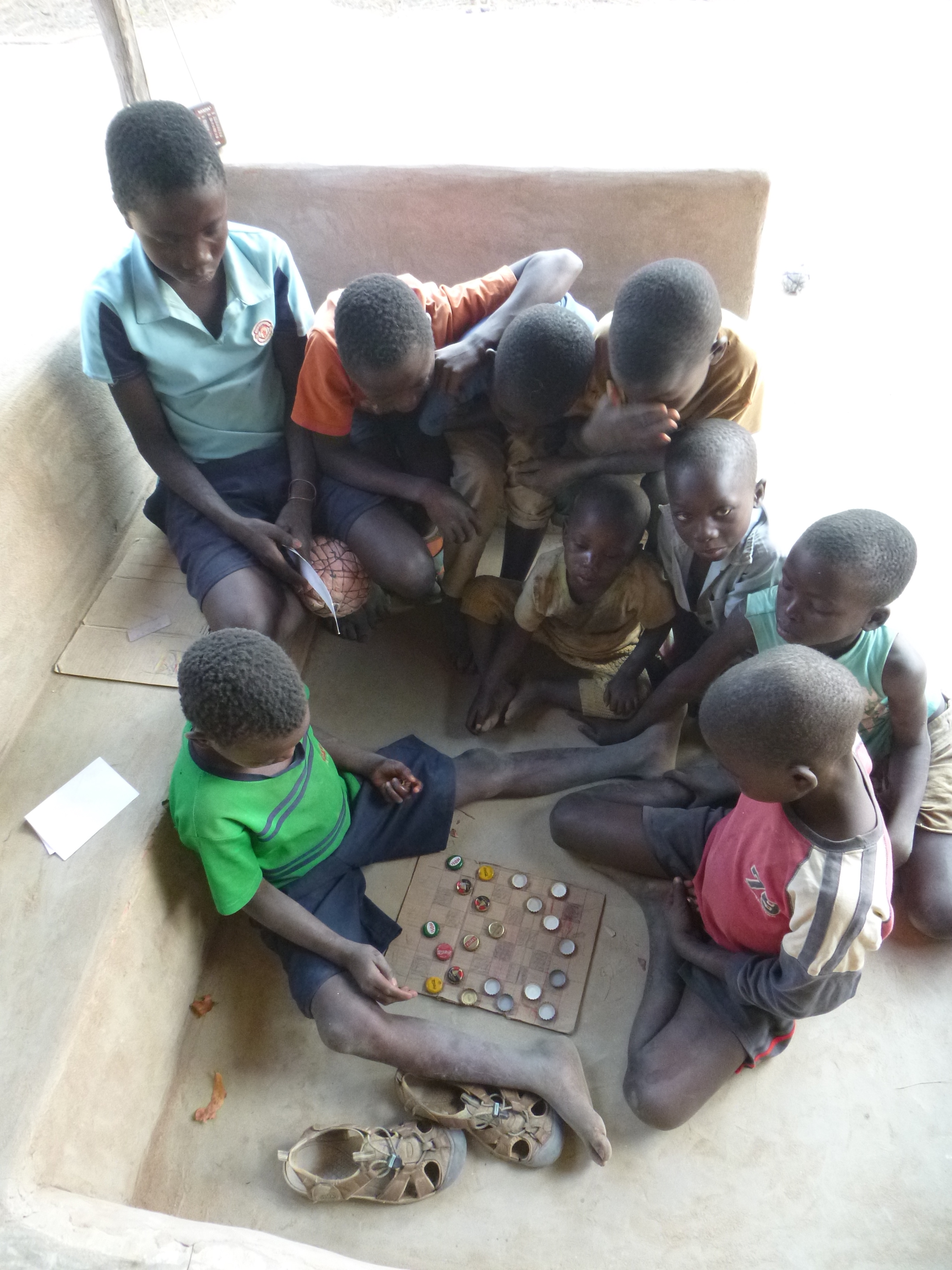 Boke and Allan Jr. play an intense game of drafts on my new front porch. Drafts is kinda like checkers, using bottle caps, a hand-drawn cardboard board, and slightly different rules.