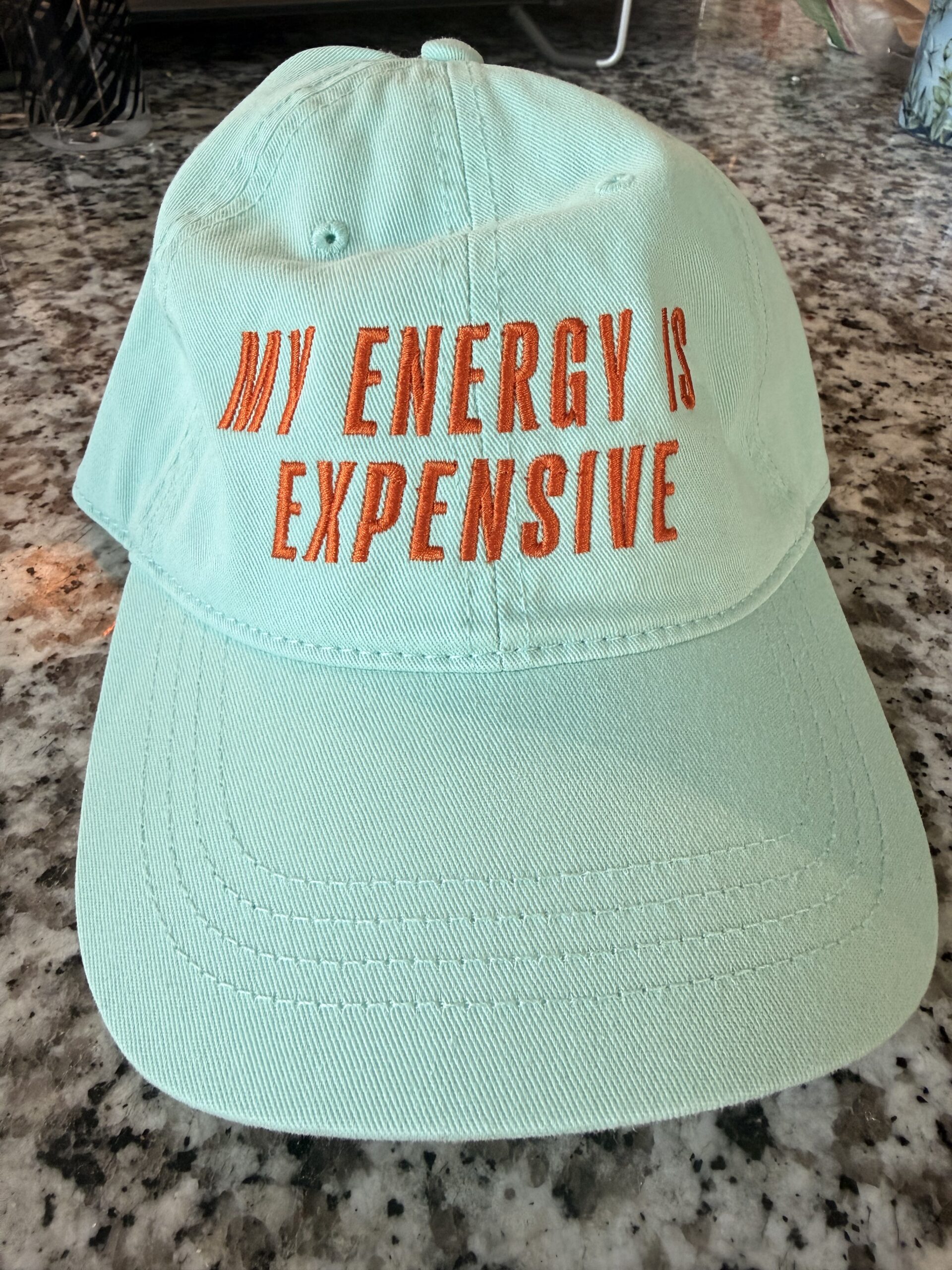 Green hat with orange text "My Energy is Expensive"