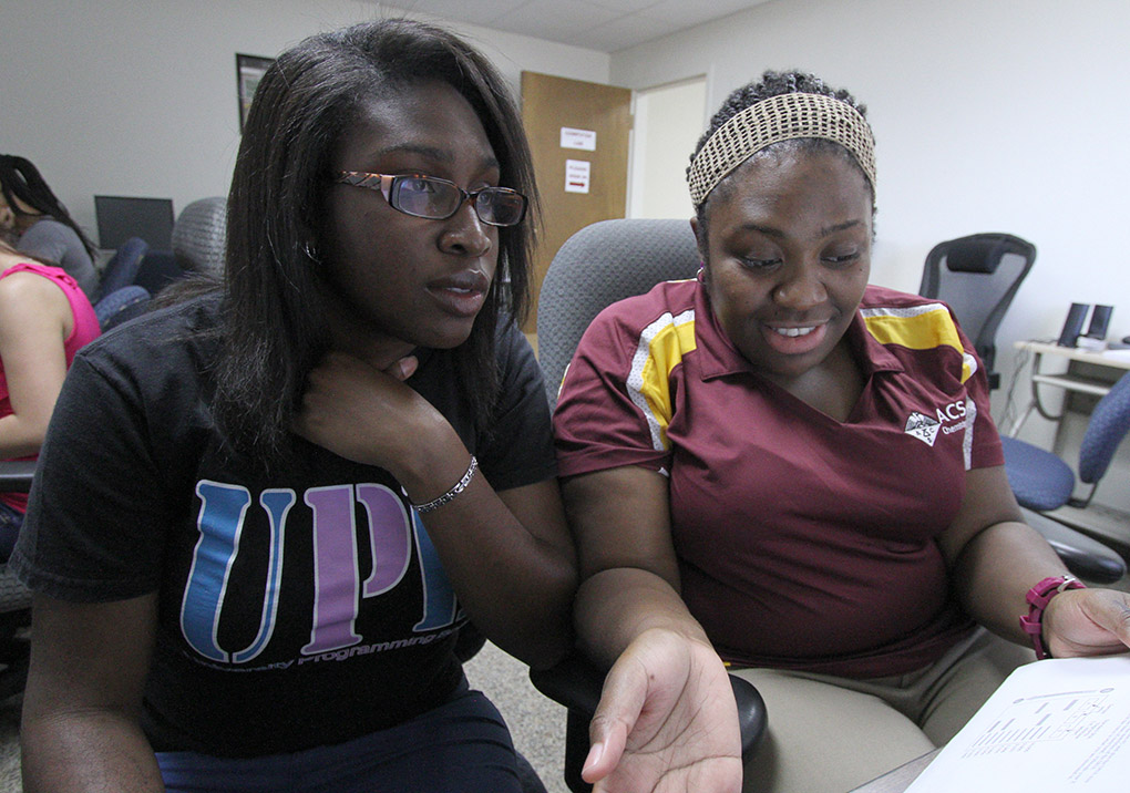 Chanez Symister, chemistry senior, helps Algerr Remy, biology senior, with some of her homework Tuesday in the Student Support Services computer lab in MaGaha Hall. Symister has been a teacher’s assistant in chemistry for two years. Symister said, "After graduation I would like to work in industry. I love synthesis. You get to work in a lab to make something." Photo by Lauren Roberts
