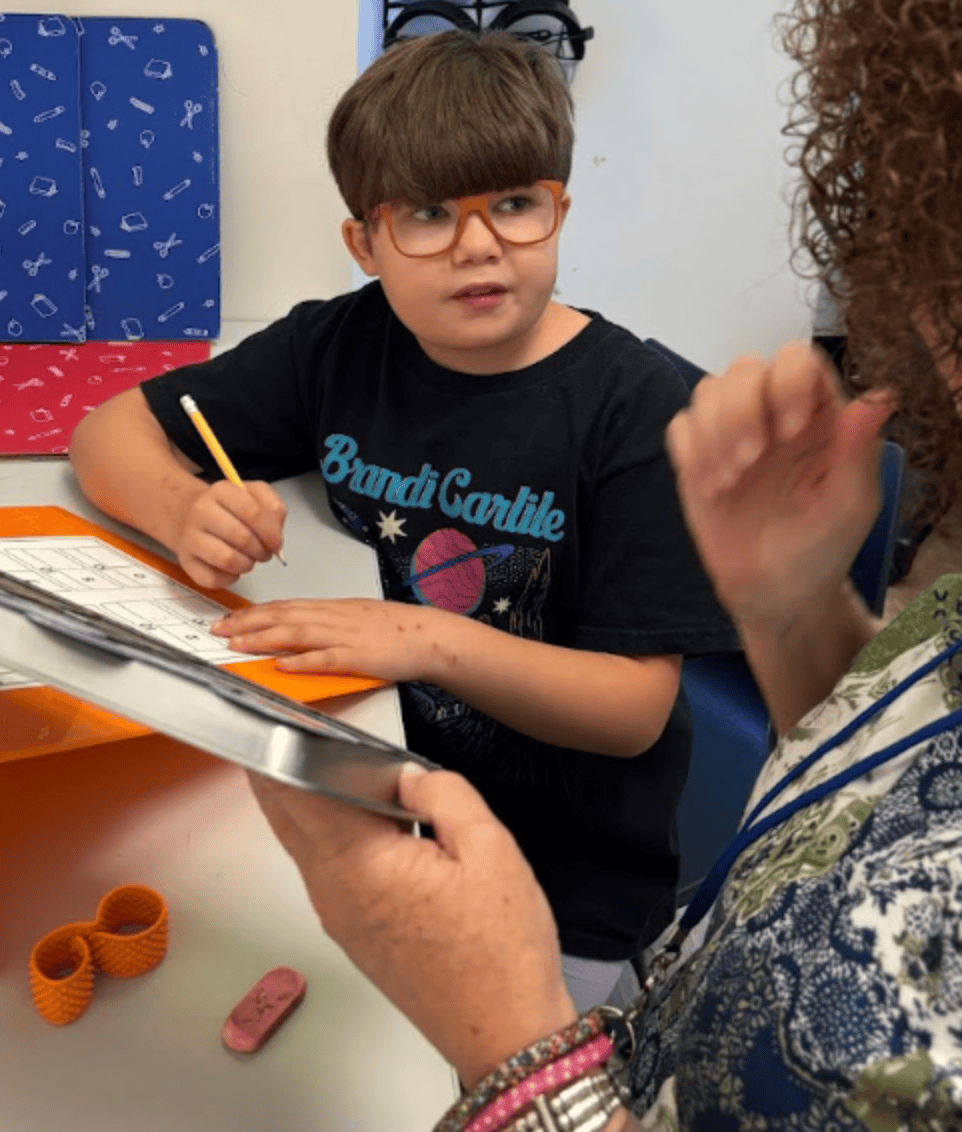 Student works on math with staff member