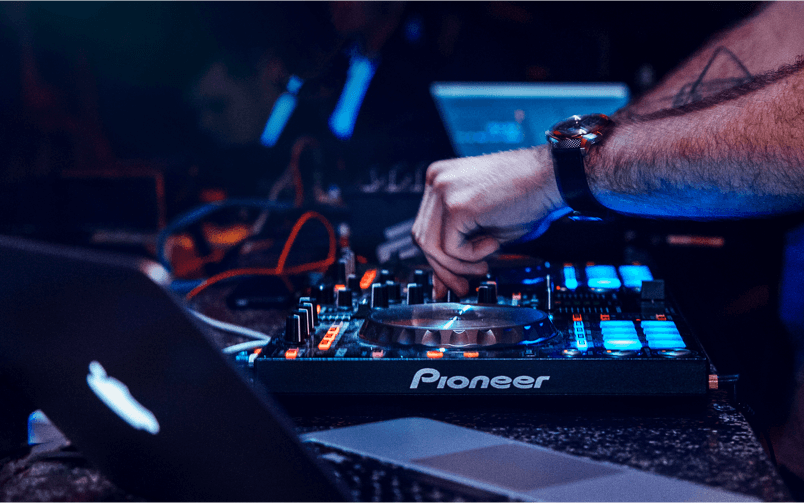 DJ adjusting controls on a Pioneer mixer during a live set.