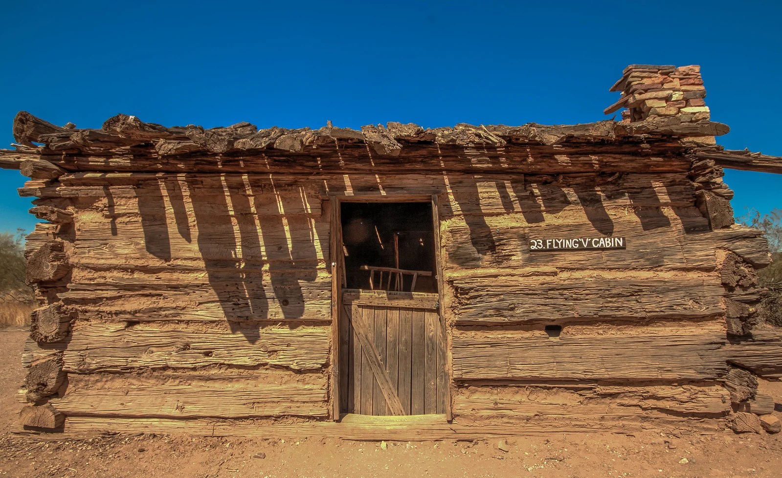 Flying V Cabin Phoenix exterior—1880 log walls, half-door and desert sky at Pioneer Living History Museum