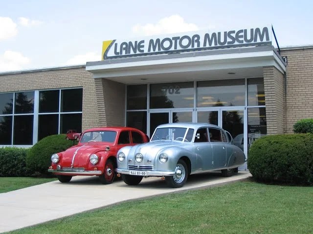 Entrance of Lane Motor Museum, Nashville, flanked by two vintage cars