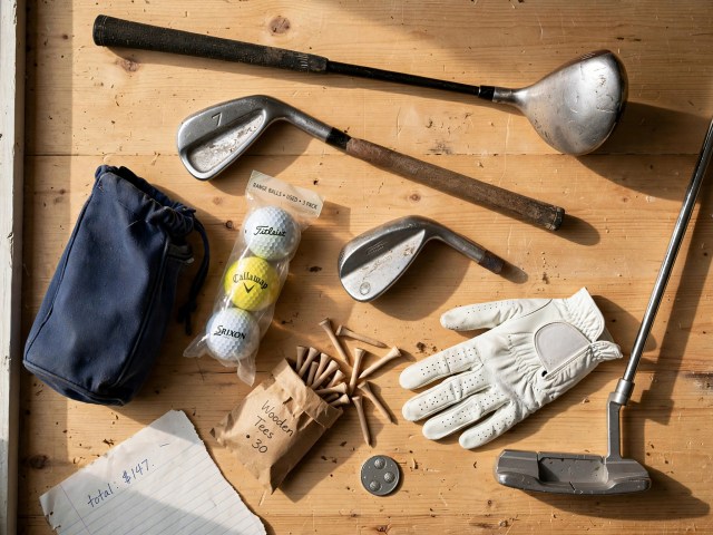 Beginner golf starter kit laid flat — used second-hand clubs, golf bag, range balls, tees and glove showing realistic affordable cost to start playing golf