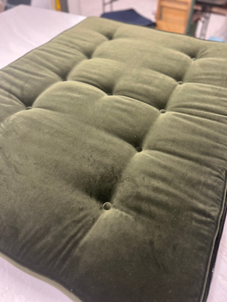 Hand-tufted seat cushion in a buttery soft forest green low pile velvet fabric.